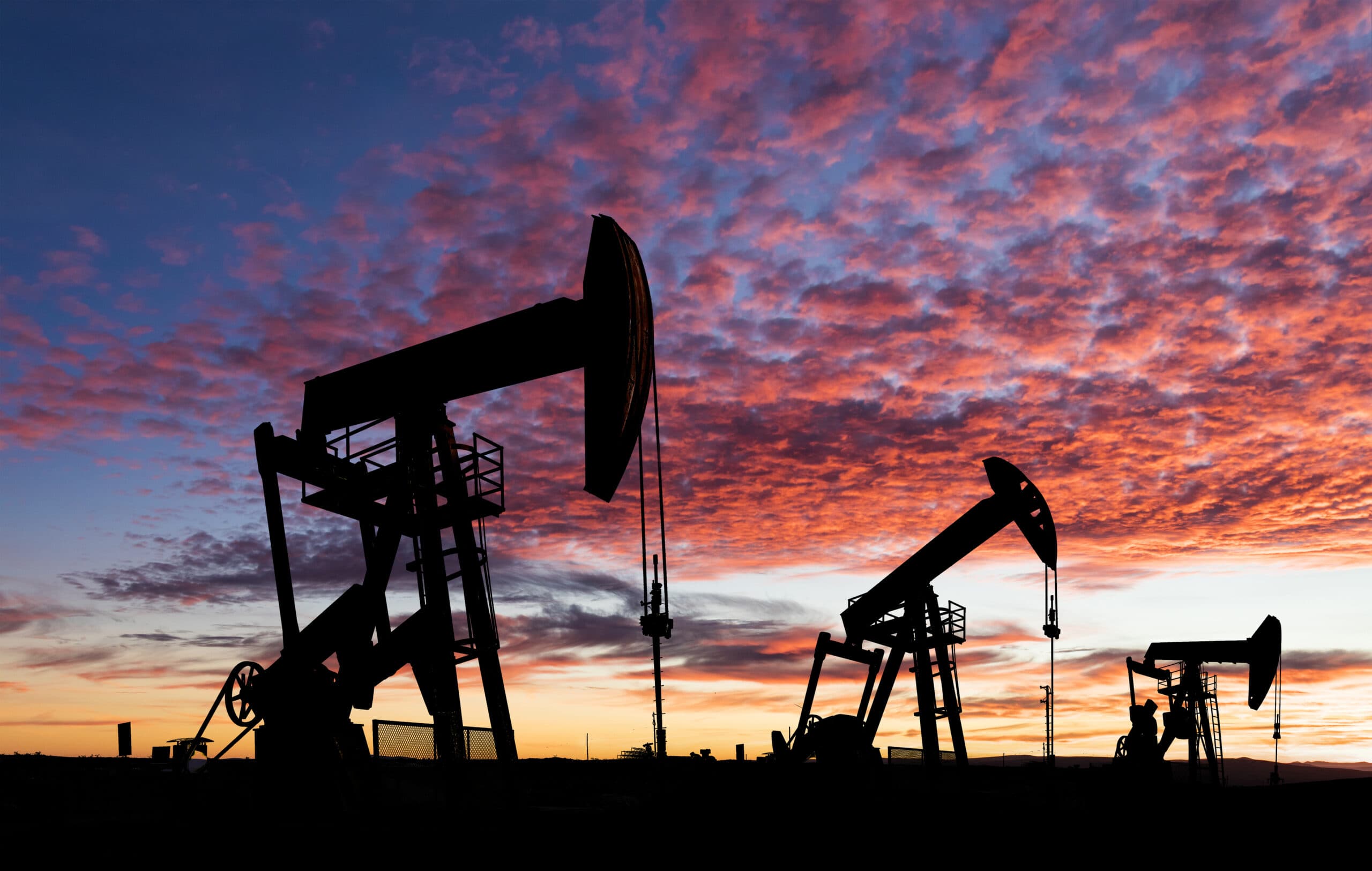 Working oil pumps against a sunset sky.