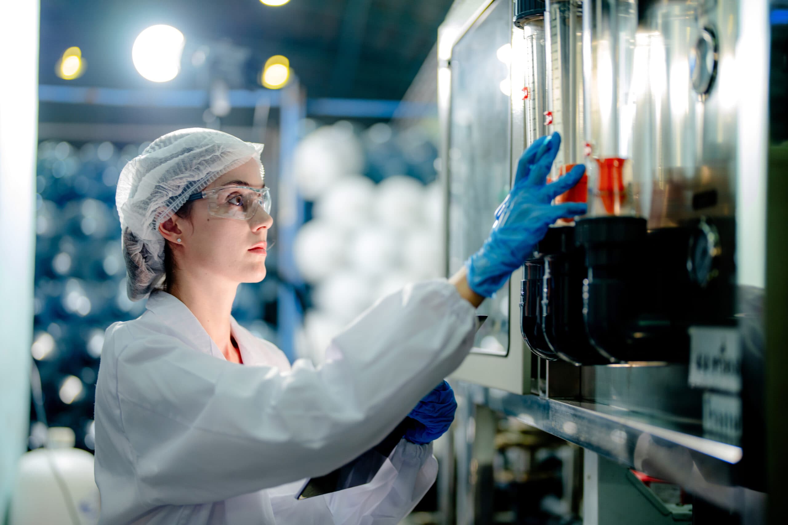scientist worker checking the quality of Reverse osmosis machine system at the industrial factory. Female worker recording data at the control panel with measure pressure for recycle portable plant.