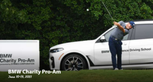 A man swinging a golf club at the BMW Charity Pro-Am event.